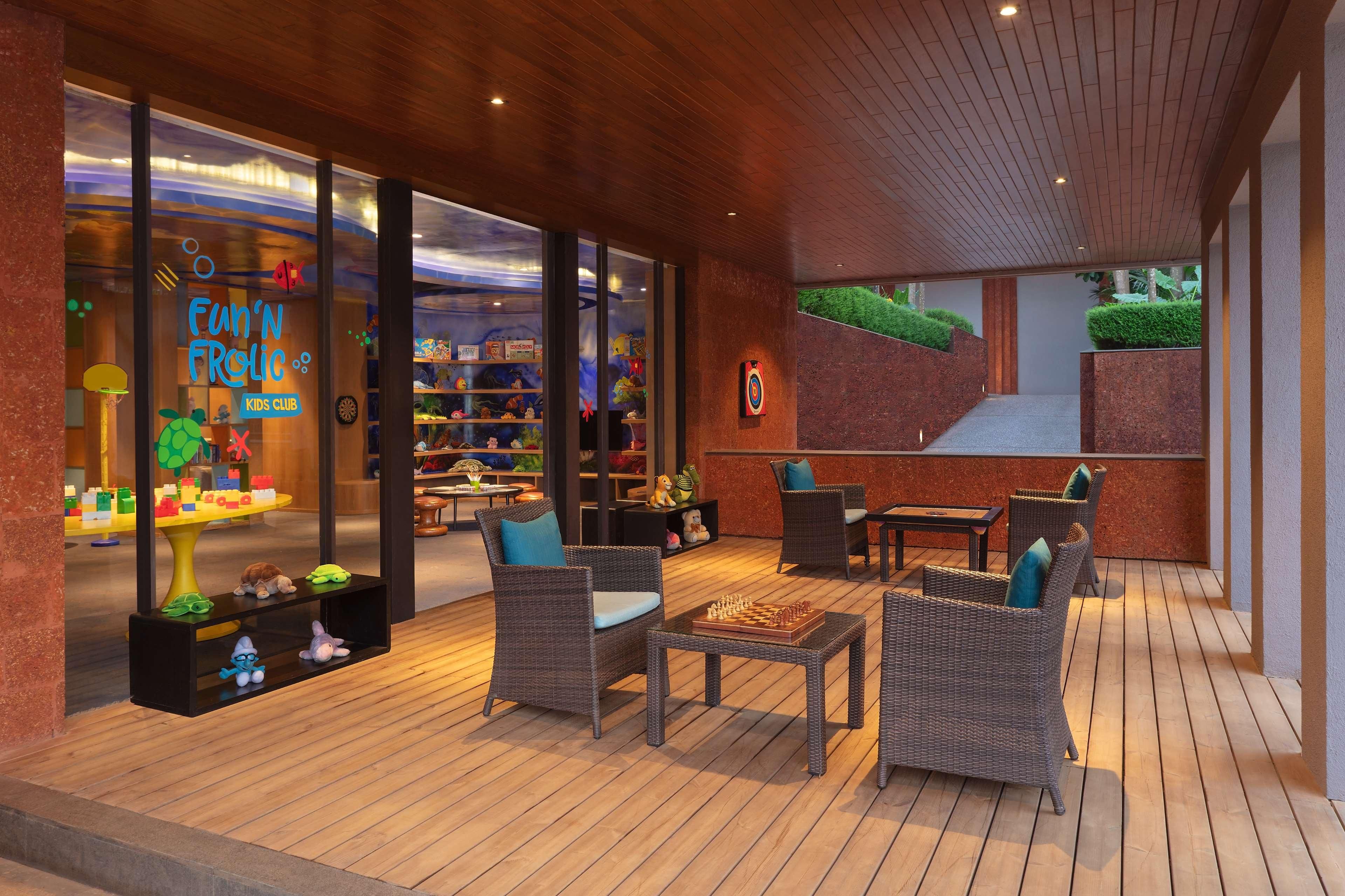 An outdoor seating area with wicker furniture and a chessboard.