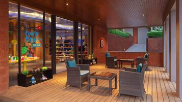 An outdoor seating area with wicker furniture and a chessboard.