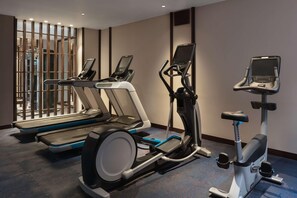 Kuntosali, jossa on juoksumattoja, kuntopyörä ja crosstrainer.