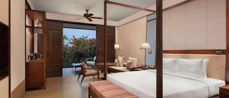 A four-poster bed with a bench, a ceiling fan, a TV, and a balcony with outdoor furniture.