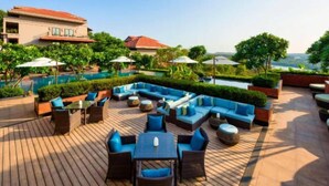 Una terraza en la azotea con mobiliario exterior, piscina y vistas del paisaje.