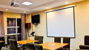 A conference room with a projector, a screen, and a television on the wall. - Greentree Inn Shandong Rizhao East Haiqu Road Business Hotel (Rizhao)