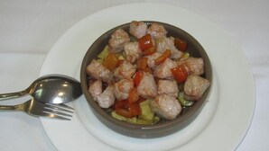 Un bol de nourriture avec une cuillère, le tout posé sur une assiette blanche.