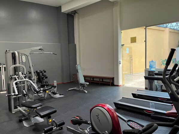 A gym with exercise equipment, a bench, and a treadmill. - Hotel Mision Pachuca (Pachuca)