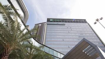 A high-rise building with a glass facade and a sign that reads "Holiday Inn".
