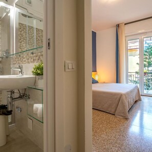 A hotel room with a bathroom, a bed, and a view of the outside. - Hotel Doria Lavagna (Lavagna)