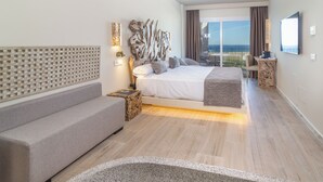 Une chambre d’hôtel moderne dotée d’un grand lit, d’un canapé, d’un bureau et d’un balcon avec vue.