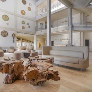 A spacious lobby with a high ceiling, multiple seating areas, and a central wooden coffee table. - Hotel Zahara Beach & Spa - Adults Only (Tarifa)