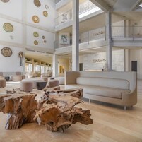 Un lobby amplio con techo alto, varias zonas de estar y una mesa de centro de madera.