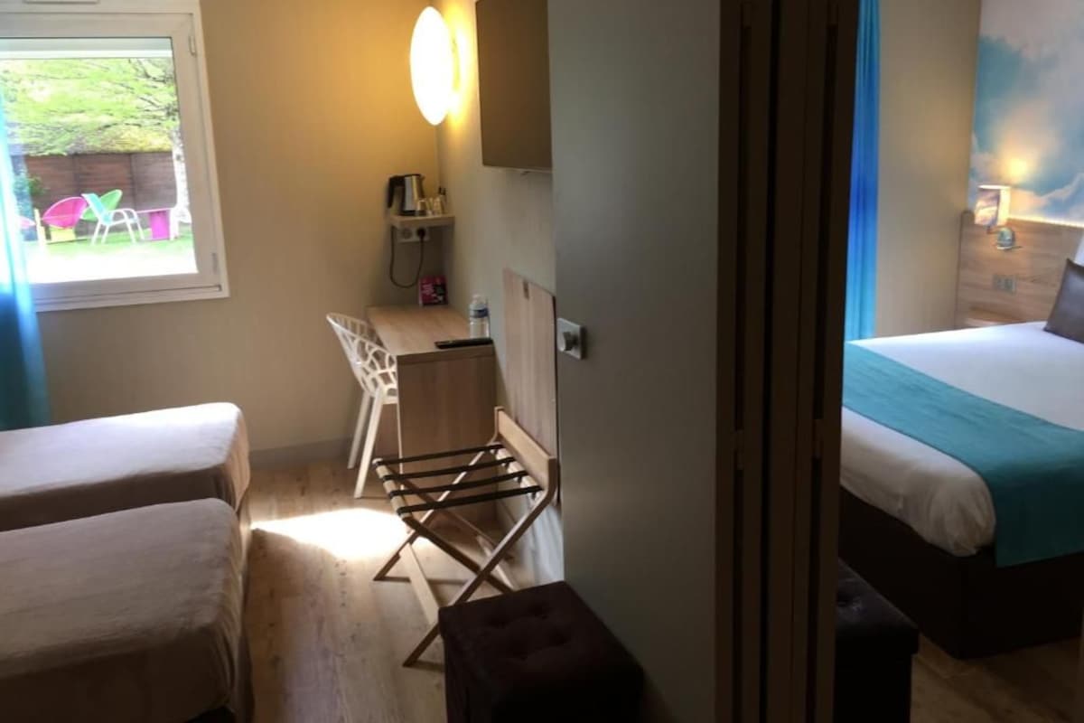 Ein Schlafzimmer mit Bett, Schreibtisch, Stuhl und Wäscheständer.