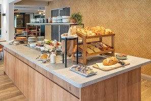 A breakfast buffet with various pastries, bread, and condiments. - Sure Hotel by Best Western Tours Sud (Chambray-les-Tours)