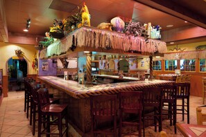 A bar area with a tiki bar, wooden chairs, and a counter with a decorative top. - Holiday Inn Salem (Salem)