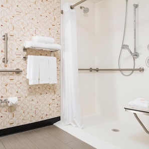 A bathroom with a shower, a towel rack, and a toilet paper holder. - Holiday Inn Salem (Salem)