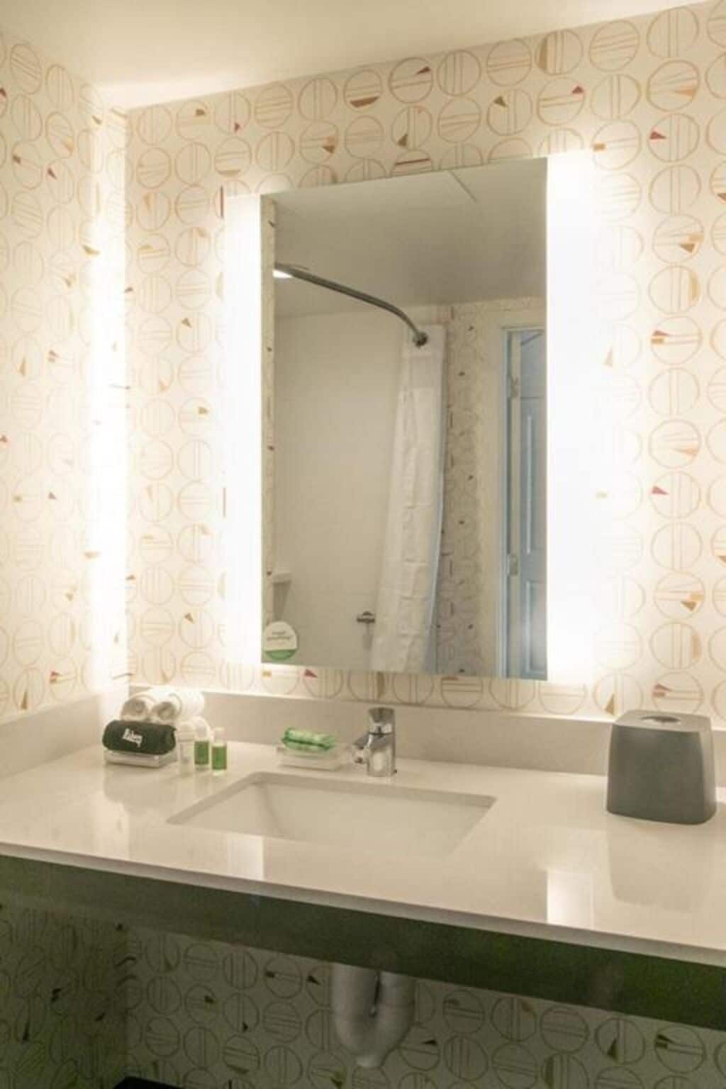 A bathroom with a white sink, a mirror, and a shower curtain.
