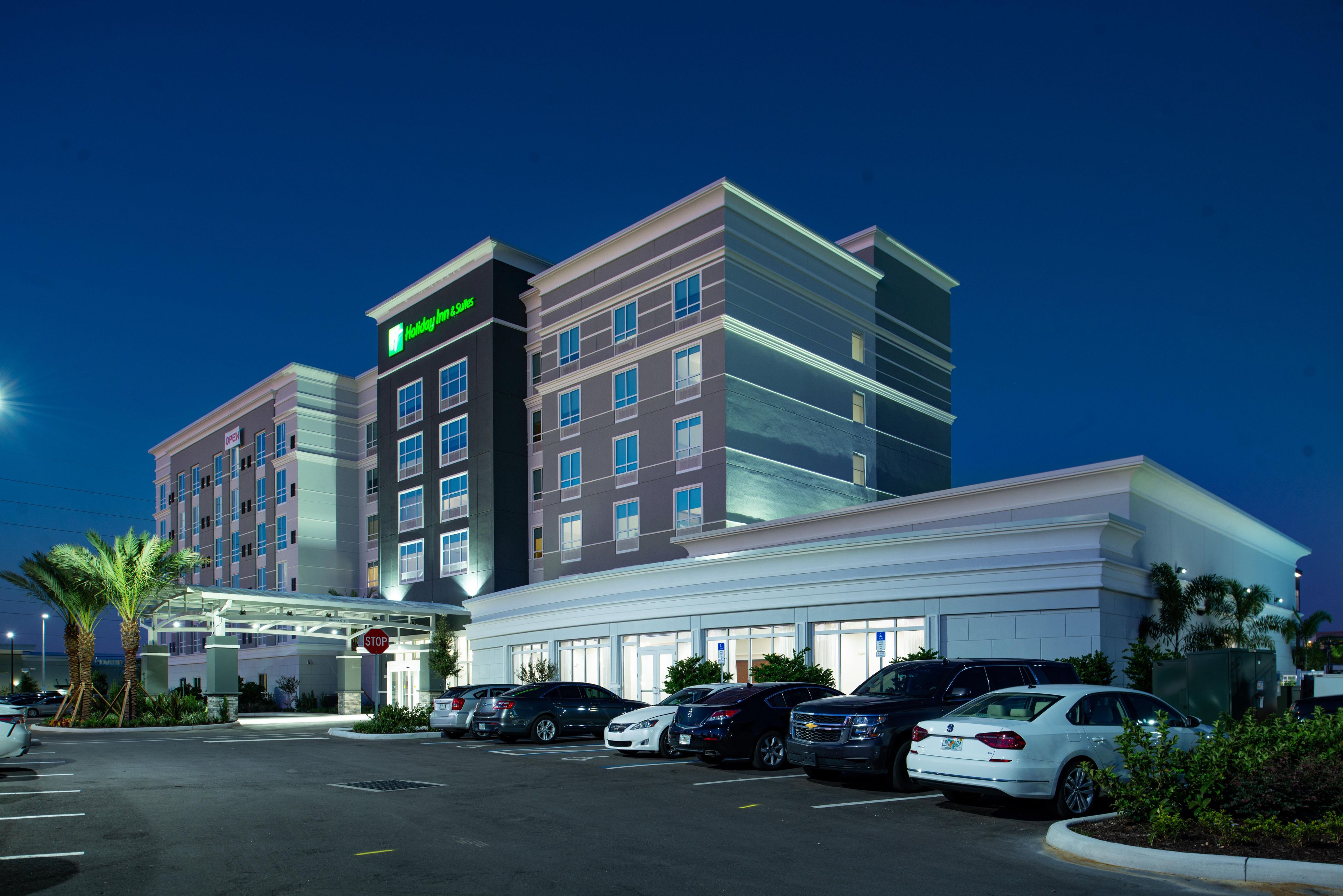 A hotel with a modern design, a parking lot, and a stop sign.