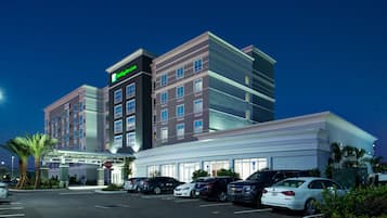 A hotel with a modern design, a parking lot, and a stop sign.