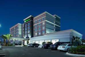 A hotel with a modern design, a parking lot, and a stop sign.