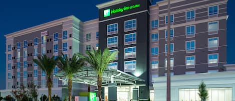 A Holiday Inn & Suites hotel with a modern design, featuring a prominent entrance and a sign indicating the hotel's name.