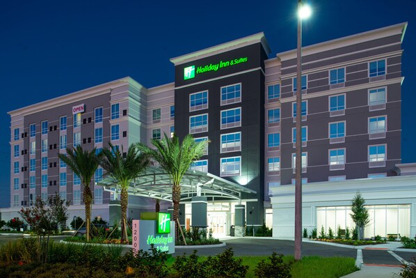 A Holiday Inn & Suites hotel with a modern design, featuring a prominent entrance and a sign indicating the hotel's name.