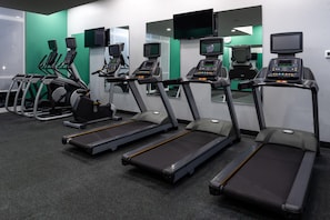 A gym with treadmills, exercise bikes, and a mirrored wall. - Holiday Inn & Suites Orlando I-drive Theme Parks (Orlando)
