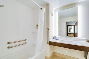 A bathroom with a bathtub, a sink, a mirror, and a shower curtain. - Holiday Inn Express and Suites Custer (Custer)