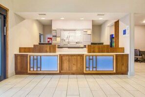 A reception desk with a modern design, featuring a wooden finish and integrated lighting. - Holiday Inn Express and Suites Custer (Custer)