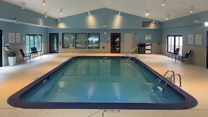 Ein Hallenbad mit gut sichtbarer Beschilderung, einer Uhr und einem Feuerlöscher.