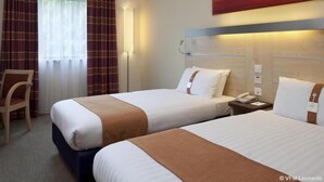 A hotel room with two beds, a chair, a bedside table with a phone, and a painting on the wall. - Holiday Inn Express Birmingham - Walsall (Walsall)