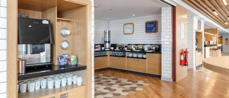 A modern kitchen with wooden cabinets, a coffee machine, and a variety of kitchenware.