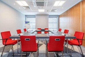 A conference room with a long table, red chairs, and a whiteboard. - Holiday Inn Express Birmingham - Walsall (Walsall)