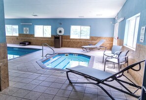 An indoor swimming pool with lounge chairs and a changing room. - Holiday Inn Express & Suites Torrington (Torrington)