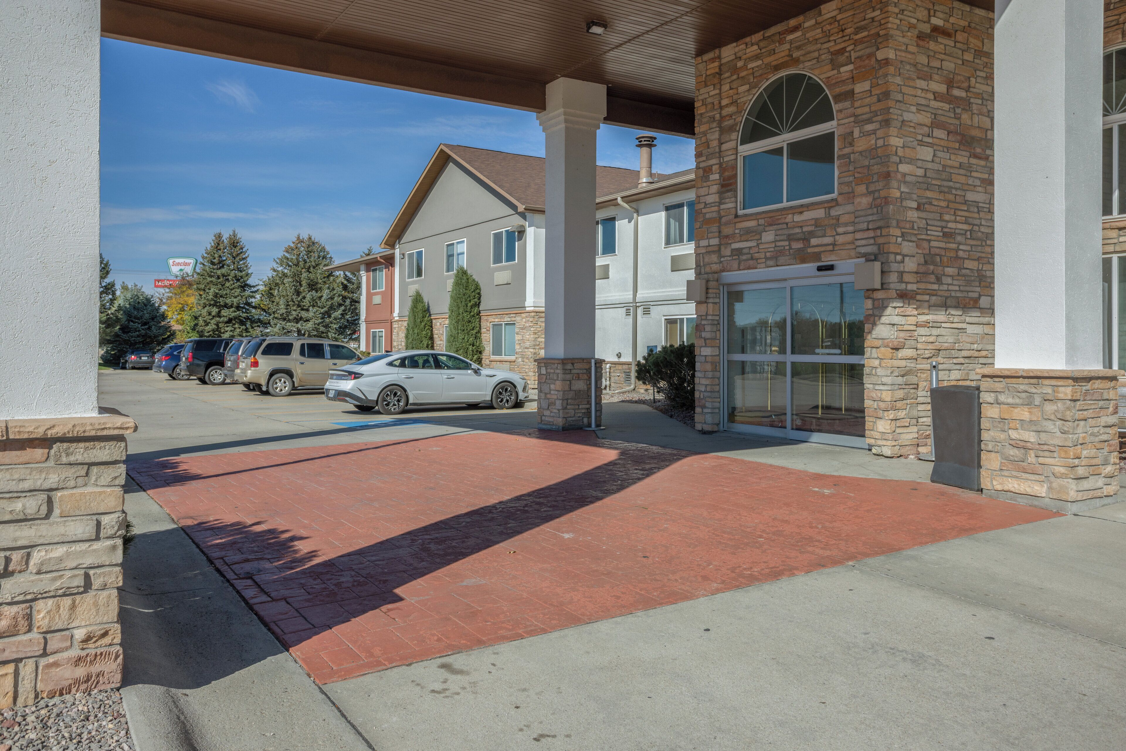 A building with a covered entrance, stone pillars, and a red carpet leading to the entrance.