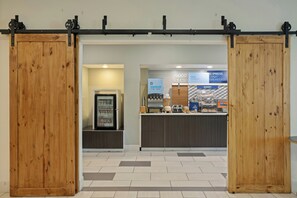 A bakery counter with a sign that reads 'EXPRESS START BREADFAST' and a display of baked goods. - Holiday Inn Express & Suites Torrington (Torrington)