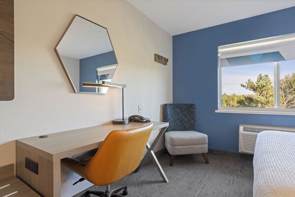 A hotel room with a desk, chair, and a large window with a view. - Holiday Inn Express & Suites Torrington (Torrington)