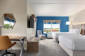 A hotel room with a desk, chair, two beds, a TV, and a window with a view.