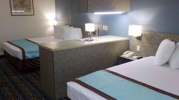 A hotel room with two beds, a small desk with a telephone, and a mirror above the desk.