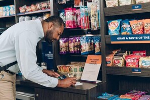 A person at a counter in a store, signing a document. - Candlewood Suites Chester Philadelphia (Chester)