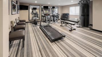 A hotel gym with treadmills, exercise bikes, and weight machines.