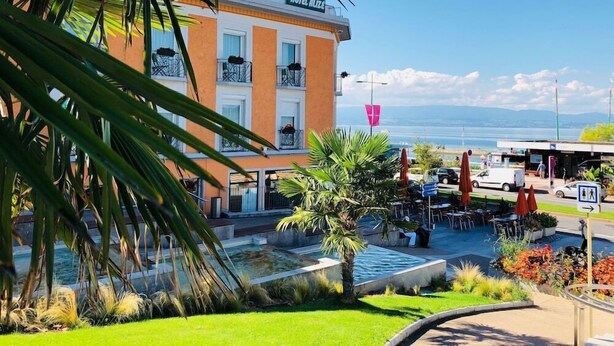 Un hotel amb piscina, mobiliari exterior i vistes al mar.