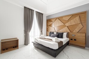 Une chambre moderne avec un grand lit, une tête de lit en bois et un banc intégré avec espace de rangement.