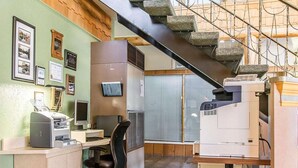 A small office with a desk, chair, printer, and a staircase leading to an upper level. - Rodeway Inn Grand Falls (St. Andre)