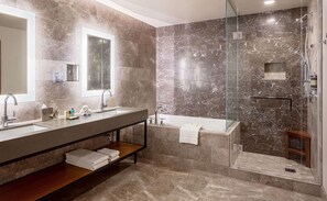 A modern bathroom with two sinks, a large mirror, a glass-enclosed shower, and a wooden shelf. - Hyatt Regency Lake Washington (Renton)