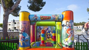 An inflatable bouncy castle with 'Goofy' branding, featuring multiple characters and a slide. - Seth Mestral & Llebeig (Es Migjorn Gran)