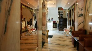 Un vestíbulo con suelo de mármol, un mostrador de recepción y una escalera.