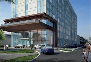 A modern hotel with a glass facade, a covered entrance, and a landscaped driveway. - Premier Inn Dubai Dragon Mart (Dubai)