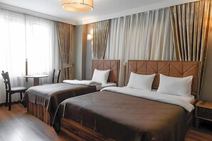 A hotel room with two beds, a small table, a chair, and curtains. - Madame Roza (Istanbul)