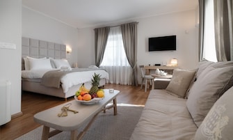 Una habitación de hotel moderna con cama, sofá, escritorio y televisor.