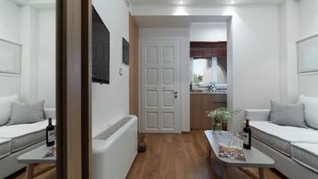 Una sala de estar moderna con un sofá, una mesa de centro y una puerta que da a la cocina.