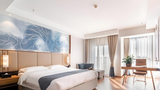 A modern hotel room with a large bed, a desk, a chair, and a large abstract painting on the wall. - Greentree Inn Jiangsu Wuxi Hudai Fuan Commercial Plaza Business Hotel (Wuxi)