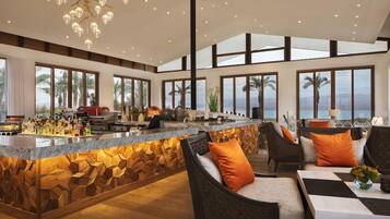 A spacious living area with a kitchen island, large windows, and a view of the outdoors.